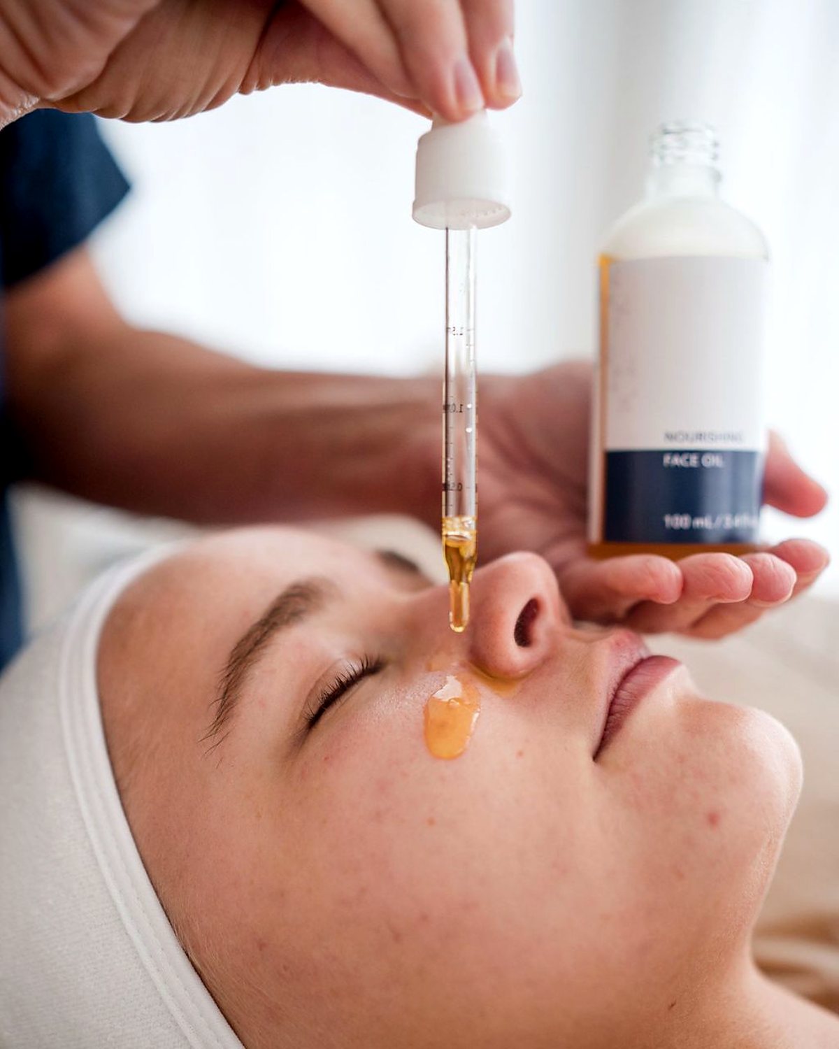 Nourishing face oil being applied during a facial